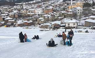 Büyükorhan'da tahta kızak ve naylonlarla kar keyfi